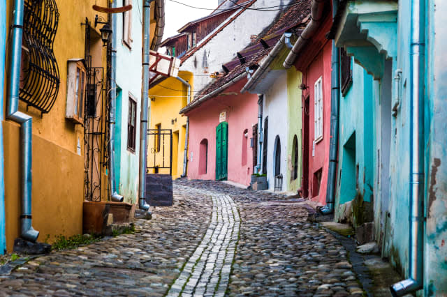 Multi coloured houses on cobbled street in Sighisoara, Transylvania, Romania