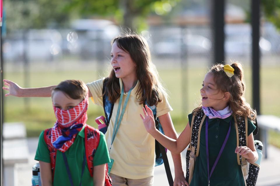 Vero Beach Elementary School students wave to the car loop line on Wednesday morning during the first day of school. Students returned from summer break to fully in-person classes with no mask mandate.