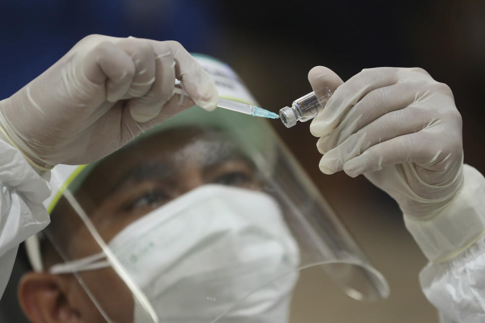 A health worker prepares a shot of COVID-19 vaccine during a mass vaccination for traders at Tanah Abang Market in Jakarta, Indonesia, Thursday, Feb. 18, 2021. Public workers, people over 60 and traders and security personnel are next in line for COVID-19 shots in Indonesia, after more 1.1 million mostly health workers received the vaccine in the first phase of inoculation. (AP Photo/Achmad Ibrahim)