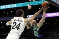 Utah Jazz's Walker Kessler (24) and Boston Celtics' Blake Griffin (91) reach for a rebound during the first half of an NBA basketball game Friday, March 31, 2023, in Boston. (AP Photo/Michael Dwyer)