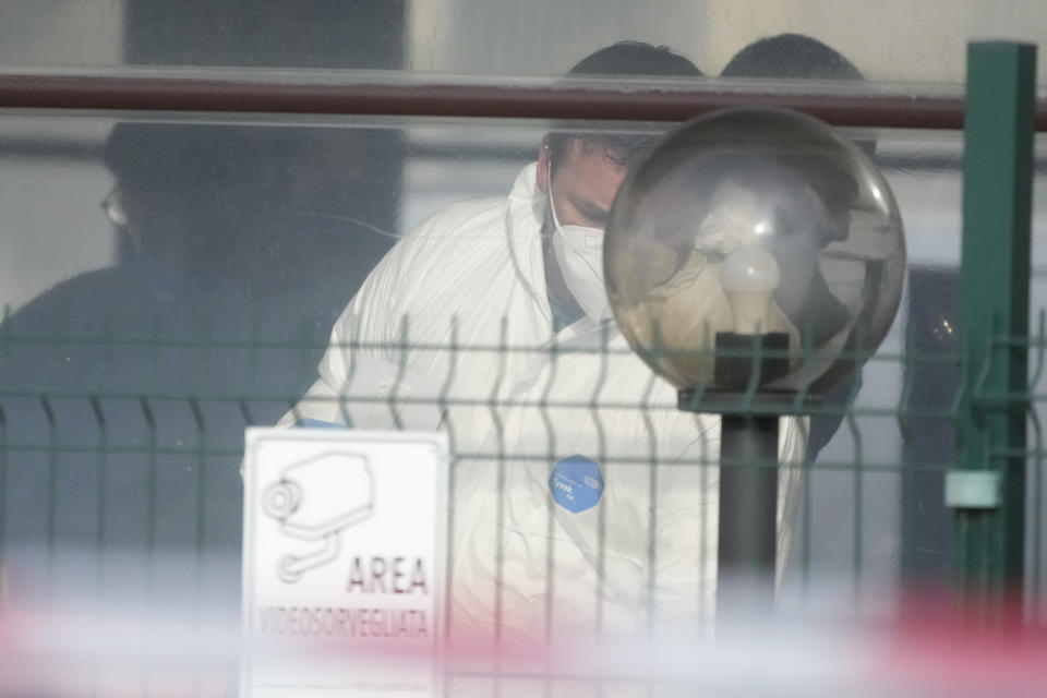 Forensic police officers inspect a bar where three people died after a man entered and shot in Rome, Sunday, Dec. 11, 2022. (AP Photo/Gregorio Borgia)