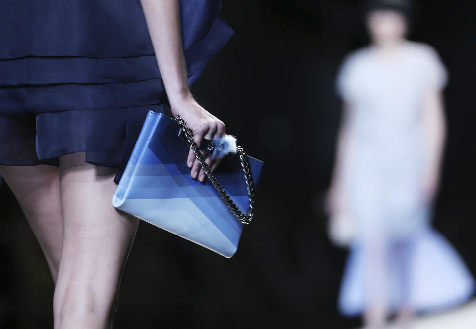 FILE - This Sept. 19, 2013 file photo shows a model holding a purse as she models a creation for the Fendi women's Spring-Summer 2014 collection during Milan Fashion Week in Milan, Italy. After weeks of top designer runway previews of spring styles at marathon fashion weeks in New York, London, Milan and Paris, the eye started to wander and it caught the newest trends for handbags and shoes. For some shoppers, accessories are at the forefront of the catwalk news they're waiting for. (AP Photo/Antonio Calanni, File)