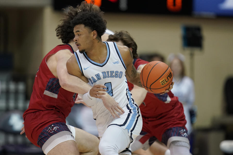 San Diego guard Deuce Turner (4) dribbles as Saint Mary's forward Kyle Bowen, left, defends during the first half of an NCAA college basketball game Thursday, Feb. 16, 2023, in San Diego. (AP Photo/Gregory Bull)