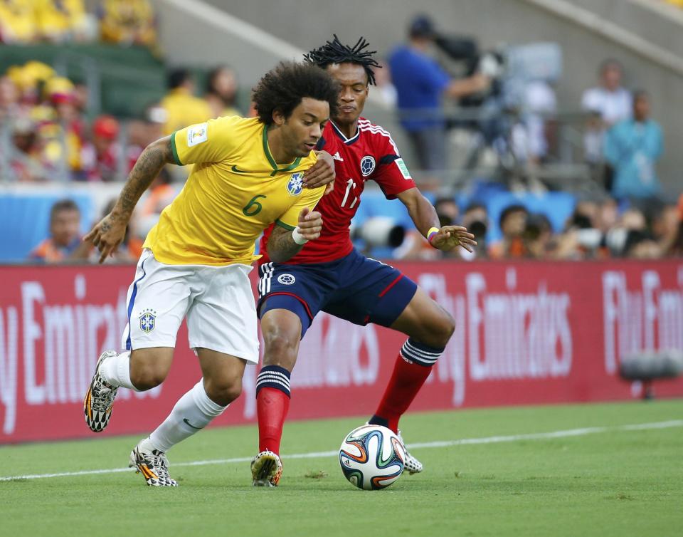 Brazil's Marcelo is challenged by Colombia's Juan Cuadrado during their 2014 World Cup quarter-finals at the Castelao arena in Fortaleza July 4, 2014. REUTERS/Yves Herman