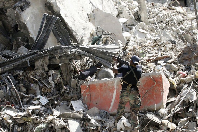 A Popular Front for the Liberation of Palestine fighter aims his rifle in the rubble of a building in the Yarmouk refugee camp in Damascus on September 12, 2013, following fighting against rebels forces who control 75 percent of the camp. President Bashar al-Assad confirmed for the first time that Syria plans to give up its chemical weapons