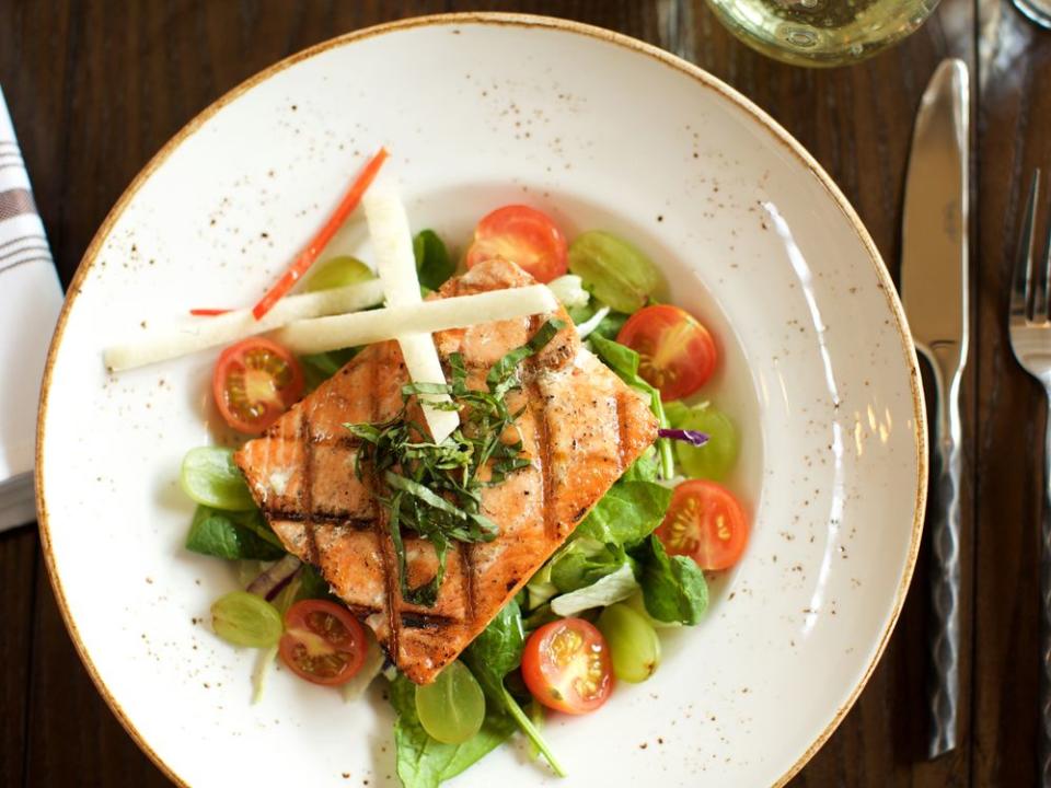 Virtuous food options, like grilled Alaskan king salmon with tomato, grape, and basil, are par for the course on Holland America's cruises. | Julie Ellis/Holland America Line