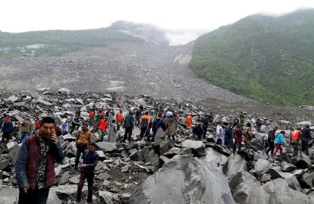 People search for survivors at the site of a landslide that destroyed some 40 households, where more than 100 people are feared to be buried, local media reports, in Xinmo Village, Sichuan Province, China June 24, 2017. REUTERS/Stringer