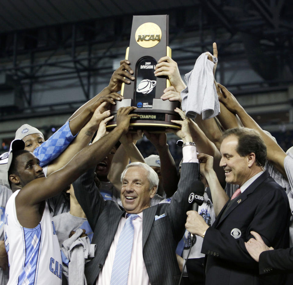 FILE - North Carolina head coach Roy Williams, center, celebrates with his team after their 89-72 victory over Michigan State in the championship game at the men's NCAA Final Four college basketball tournament in Detroit, in this Tuesday, April 7, 2009, file phto. North Carolina announced Thursday, April 1, 2021, that Hall of Fame basketball coach Roy Williams is retiring after a 33-year career that includes three national championships. (AP Photo/Paul Sancya, File)