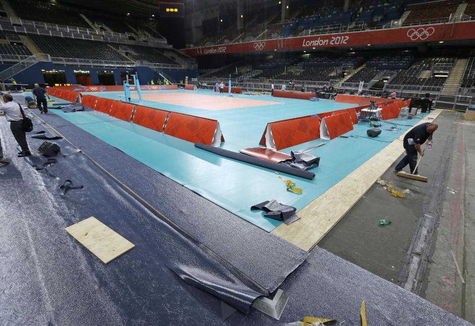 Workers prepare the main volleyball court at Earl's Court, the site of the Volleyball competition, at the 2012 Summer Olympics, Tuesday, July 24, 2012, in London. (AP Photo/Darron Cummings)