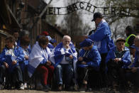 Holocaust survivors and former Auschwitz inmates participate in the annual 'March of the Living', a trek between two former Nazi-run death camps, in Oswiecim, Poland, Tuesday, April 18, 2023 to mourn victims of the Holocaust and celebrate the existence of the Jewish state. Slogan in the background reads: 'Work Sets You Free'. (AP Photo/Michal Dyjuk)