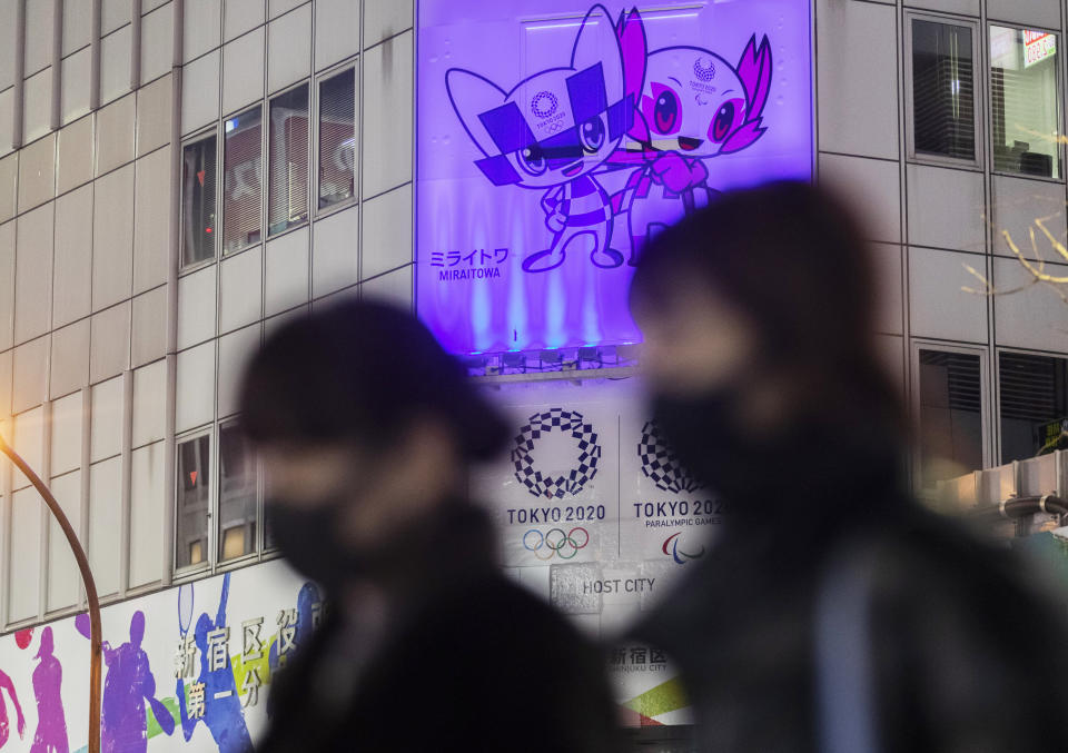 Personas con mascarillas caminan frente a carteles promocionales de los Juegos Olímpicos en Tokio, el jueves 28 de enero de 2021. (AP Foto/Hiro Komae)