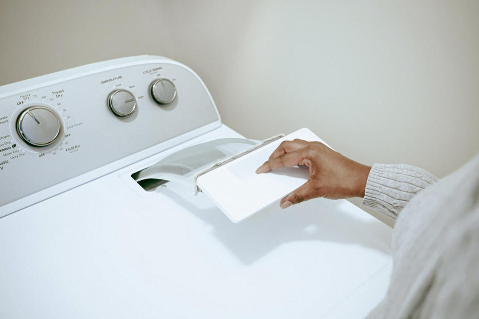 Person opening a laundry machine's detergent drawer