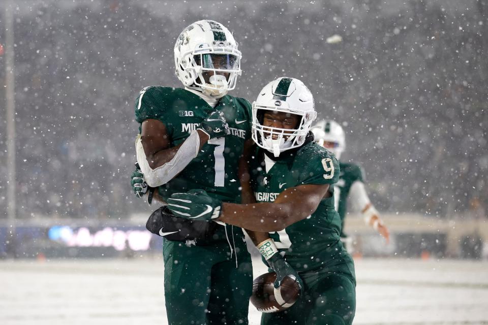 Michigan State's Jayden Reed, left, and running back Kenneth Walker III celebrate Reed's 20-yard touchdown catch on fourth down against Penn State during the fourth quarter Saturday, Nov. 27, 2021, in East Lansing, Mich. The Spartans won, 30-27.