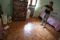 Elena Moretti looks at her cellphone as she attends an online dancing lesson, in her bedroom in Rome, Thursday, May 14, 2020 during the COVID-19 coronavirus lockdown. Sometimes the internet connection goes out. But she’s still managed to keep in touch with friends, with some video chats lasting for hours. (AP Photo/Andrew Medichini)