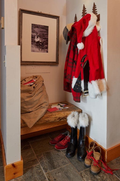 Photo of a coat rack with Santa's coat, hat and boots seen below