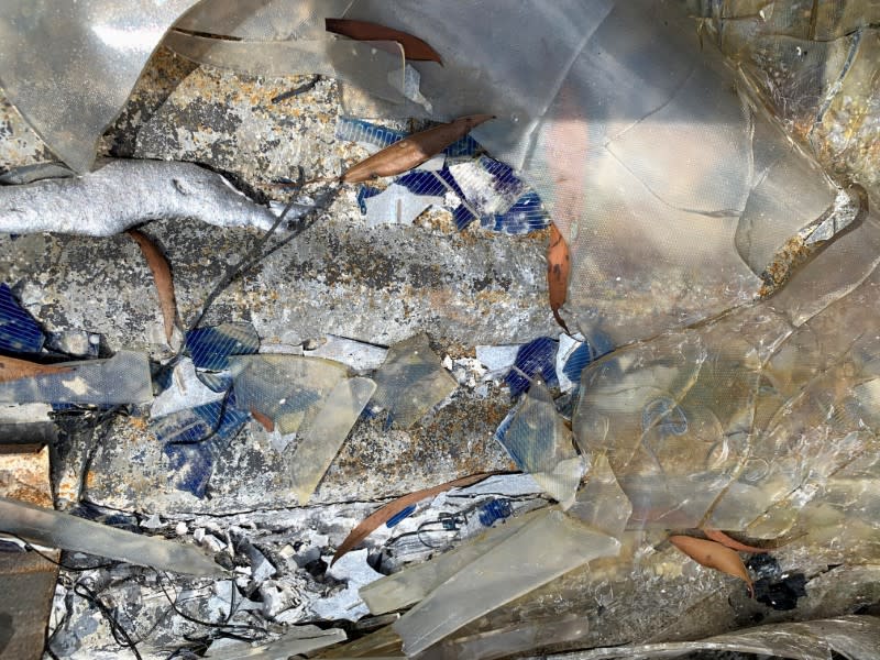 Debris from a bent, shattered window and broken solar panel (in blue color) are seen at a burnt area of the Sunnataram Forest Monastery in Bundanoon