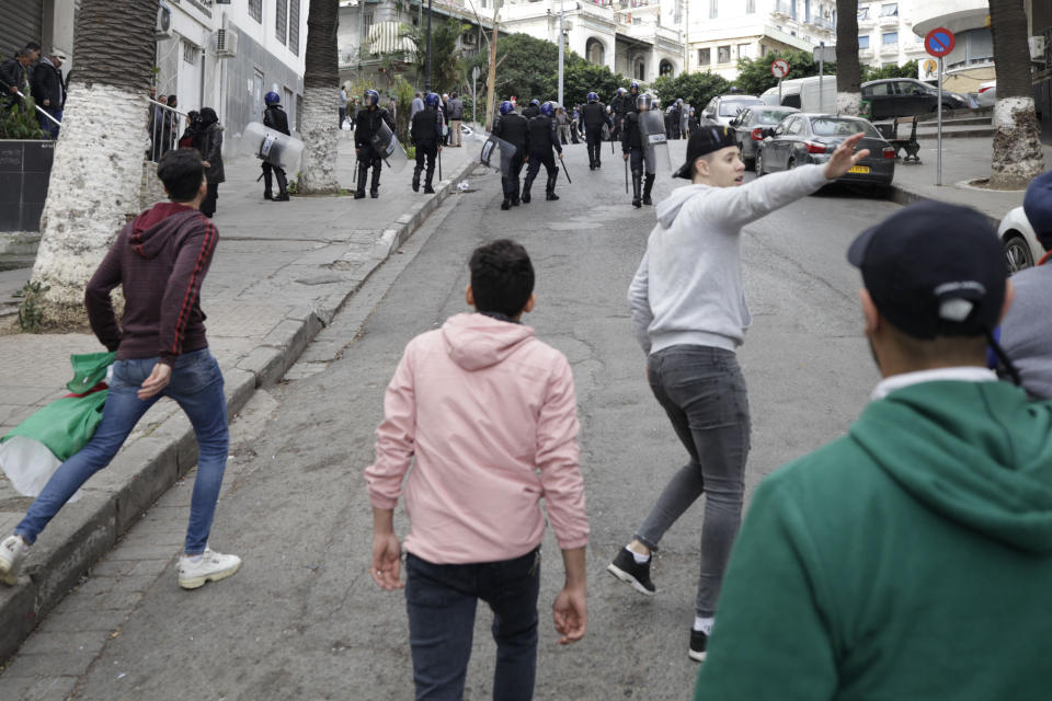 Algerian demonstrators clash with security forces as they take to the streets in the capital Algiers to reject the presidential elections, in Algeria, Thursday, Dec. 12, 2019. Five candidates have their eyes on becoming the next president of Algeria _ without a leader since April _ in Thursday's contentious election boycotted by a massive pro-democracy movement. (AP Photo)