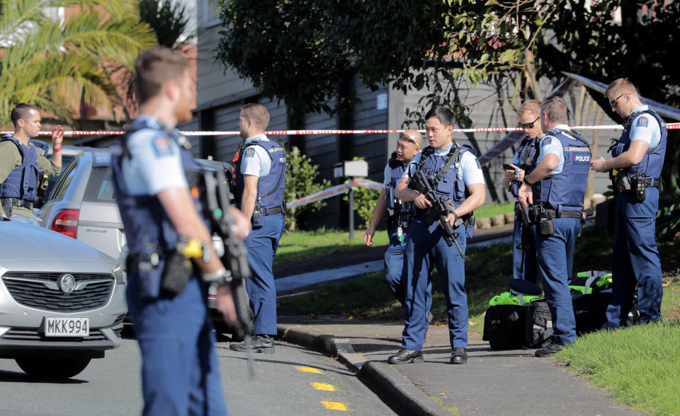 Armed police gather at the scene of a shooting incident following a routine traffic stop in Auckland, New Zealand, Friday, June 19, 2020. New Zealand police say a few officers have been shot and seriously injured and a suspect is on the run. (Michael Craig/New Zealand Herald via AP)