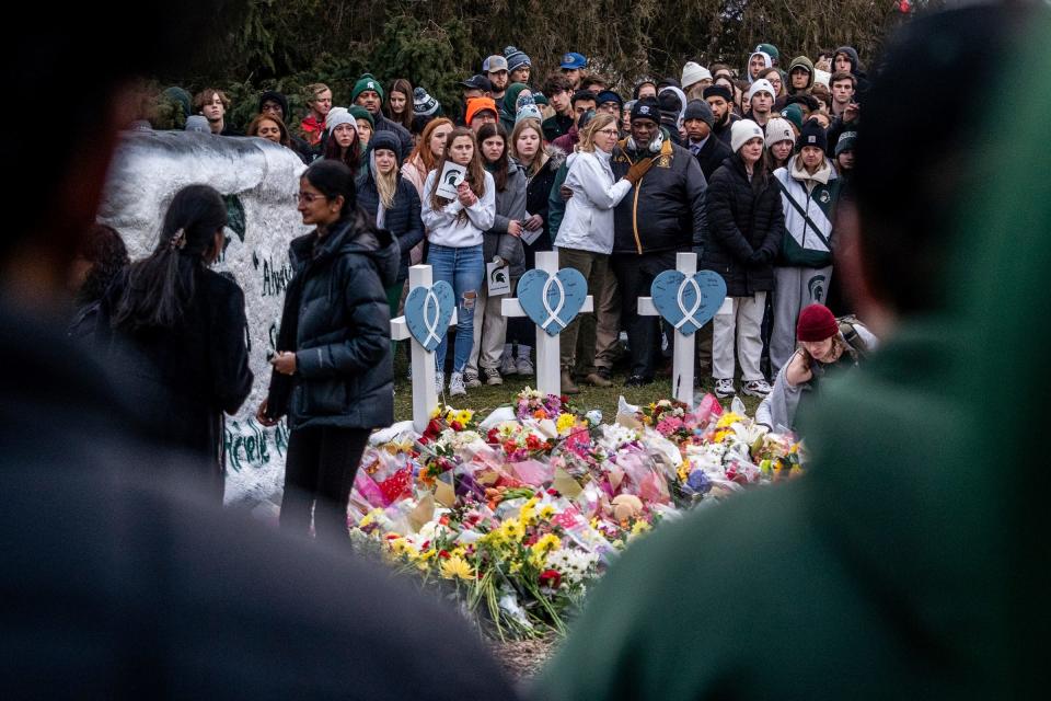 People stand together during a vigil at the Rock on the Michigan State University campus in East Lansing on Wednesday, Feb. 15, 2023, to honor and remember the victims of the mass shooting that happened on the MSU campus that left three dead and five injured.