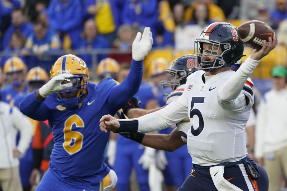 Virginia quarterback Brennan Armstrong (5) gets a pass away as Pittsburgh defensive lineman John Morgan III (6) pressures him during the first half of an NCAA college football game Saturday, Nov. 20, 2021, in Pittsburgh. (AP Photo/Keith Srakocic)