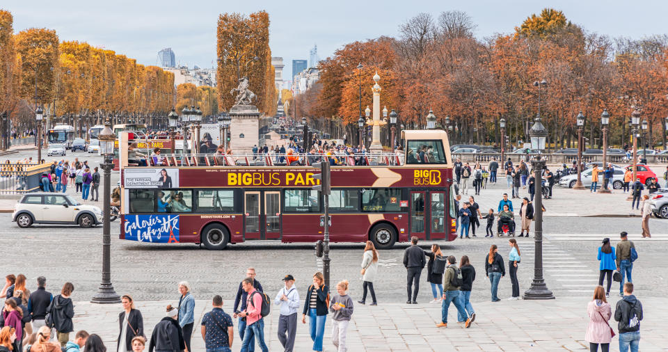 Big Bus carrying tourists in a street of Paris during autumn on Place de la Concorde Square.