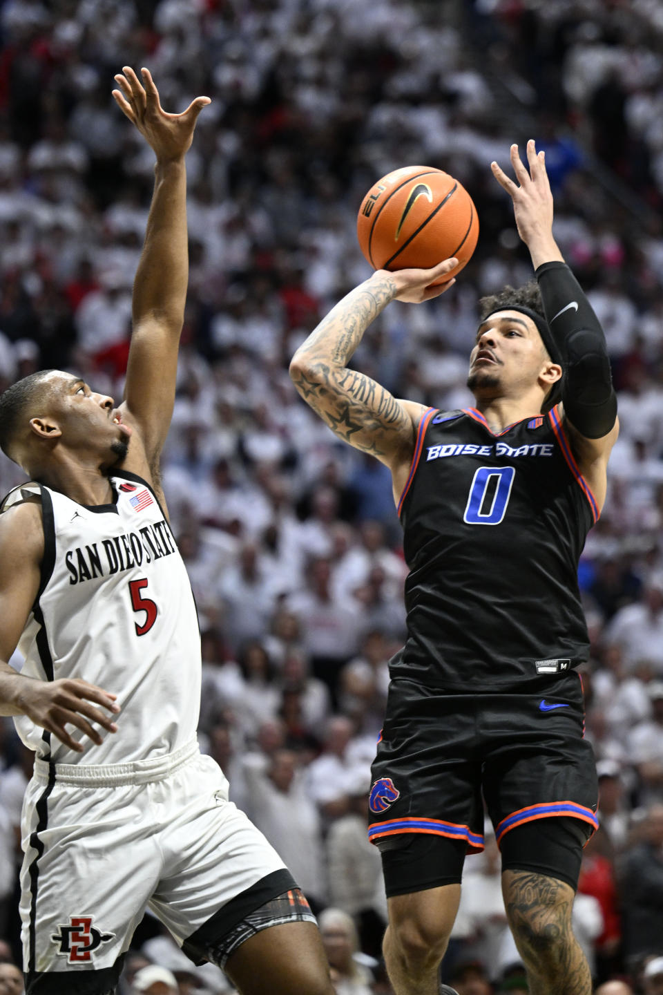 Boise State guard Roddie Anderson III (0) shoots over San Diego State guard Lamont Butler (5) during the second half of an NCAA college basketball game Friday, March 8, 2024, in San Diego. (AP Photo/Denis Poroy)