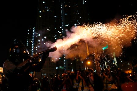 Riot police fire tear gas to disperse anti-extradition bill protesters after a march to demand democracy and political reforms, at Wong Tai Sin, Hong Kong