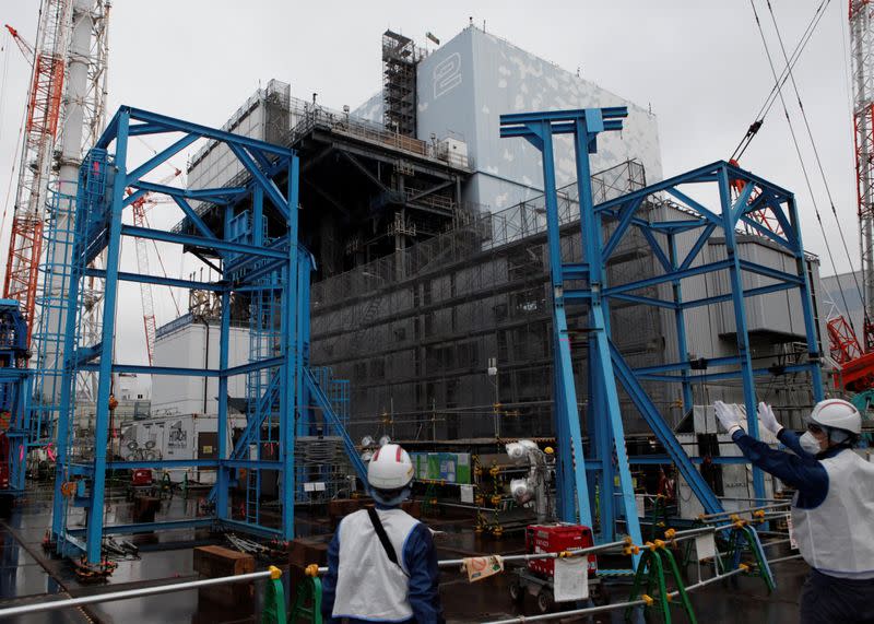 Workers are seen near the No.2 reactor building at sunami-crippled Fukushima Daiichi nuclear power plant in Okuma town, Fukushima prefecture