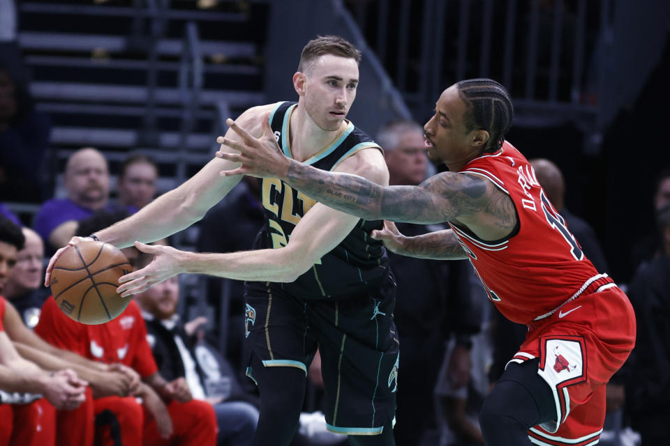 Charlotte Hornets forward Gordon Hayward, left, passes the ball as Chicago Bulls forward DeMar DeRozan defends during the first half of an NBA basketball game in Charlotte, N.C., Thursday, Jan. 26, 2023. (AP Photo/Nell Redmond)