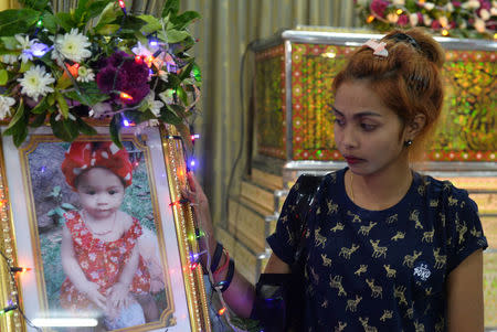 Jiranuch Trirat, mother of 11-month-old daughter who was killed by her father who broadcast the murder on Facebook, stands next to a picture of her daughter at a temple in Phuket, Thailand April 25, 2017. REUTERS/Sooppharoek Teepapan