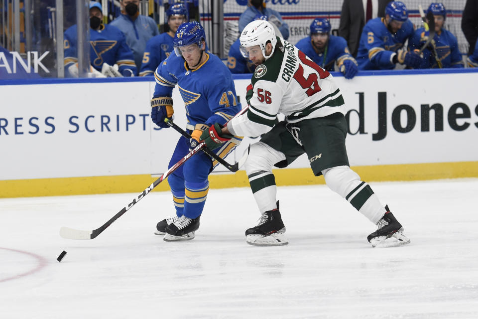 St. Louis Blues' Torey Krug (47) and Minnesota Wild's Joseph Cramarossa (56) battle for the puck during the third period of an NHL hockey game on Saturday, April 10, 2021, in St. Louis. (AP Photo/Joe Puetz)