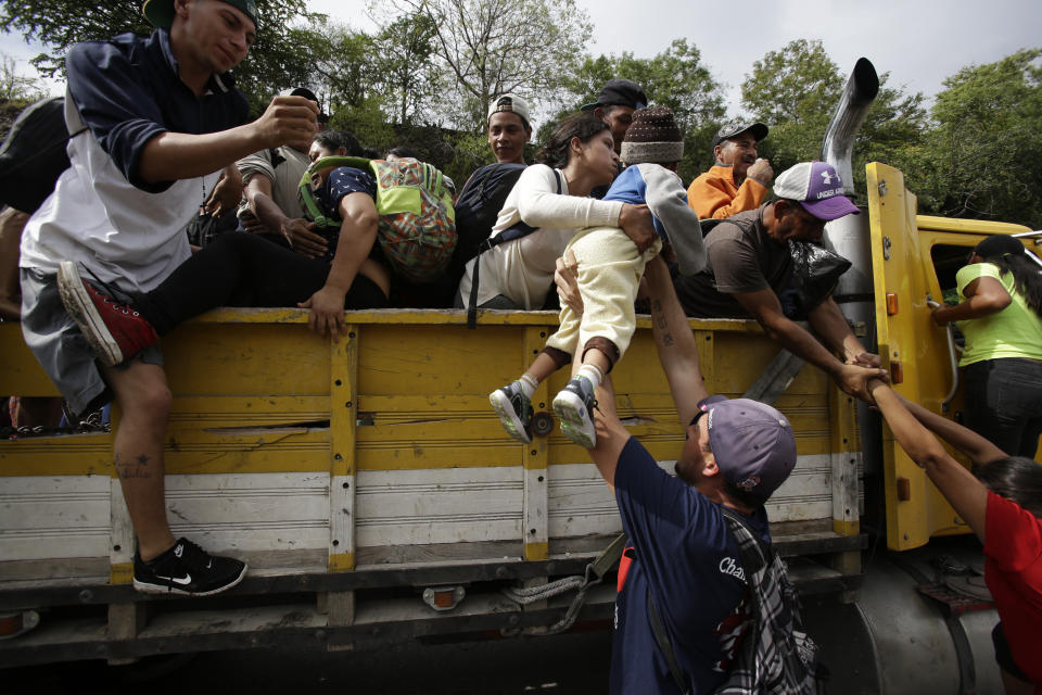 Honduran migrants bound for the U.S border climb into the bed of a truck in Zacapa, Guatemala, on Wednesday, Oct. 17, 2018. (AP Photo/Moises Castillo)