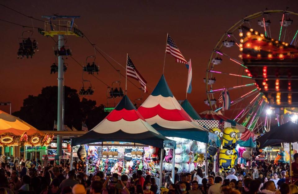 Rides and concessions cast light for visitors on the ground and riding the Sky Ride tram, left, after sunset at Cal Expo during the California State Fair on Tuesday, July 26, 2022, in Sacramento. The fair kicks off at Cal Expo in Sacramento on Friday, July 12, 2024.