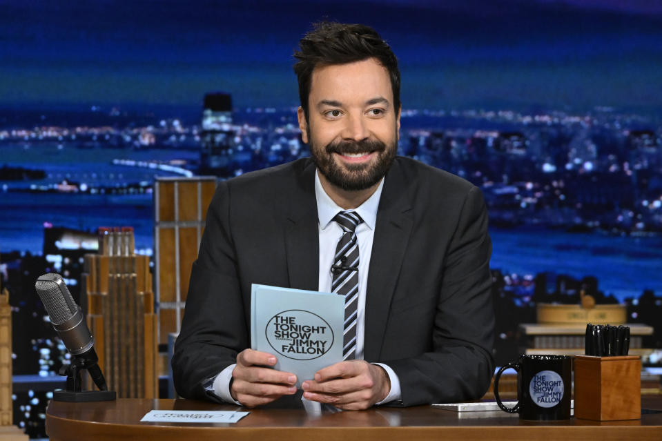 A close-up of Jimmy Fallon smiling at his desk