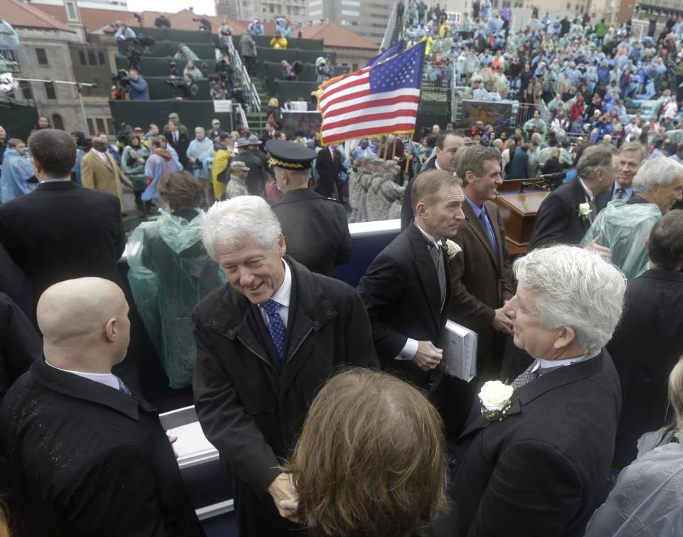 Former U.S. President Bill Clinton, center left, greets Virginia Attorney General Mark Herring, right, and his wife as they leave the inauguration of Virginia Governor Terry McAuliffe on the steps of the South Portico of the Capitol in Richmond, Va., Saturday, Jan. 11, 2014. McAuliffe was sworn in as the 72nd Governor of Virginia. (AP Photo/Steve Helber)