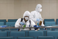 Workers in protective suits spray disinfectant as a precaution against the COVID-19 at an indoor gymnasium in Seoul, South Korea, Tuesday, Feb. 25, 2020. China and South Korea on Tuesday reported more cases of a new viral illness that has been concentrated in North Asia but is causing global worry as clusters grow in the Middle East and Europe. (AP Photo/Lee Jin-man)