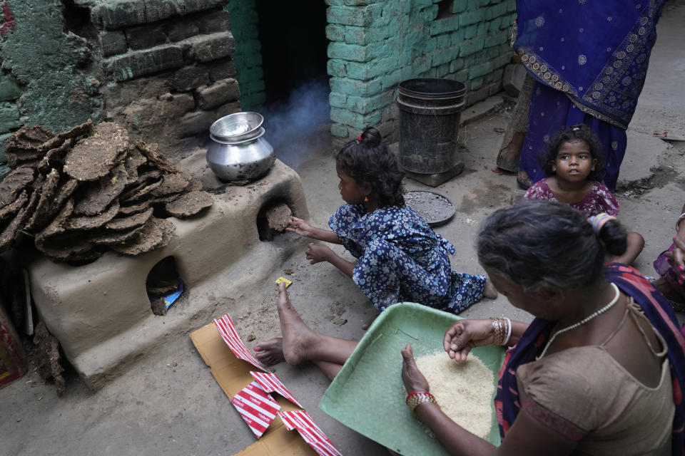 A woman from an impoverished family cleans the rice, which she received under a government scheme offering free ration, on the outskirts of Patna, in the Indian state of Bihar, on May 11, 2024. (AP Photo/Manish Swarup)