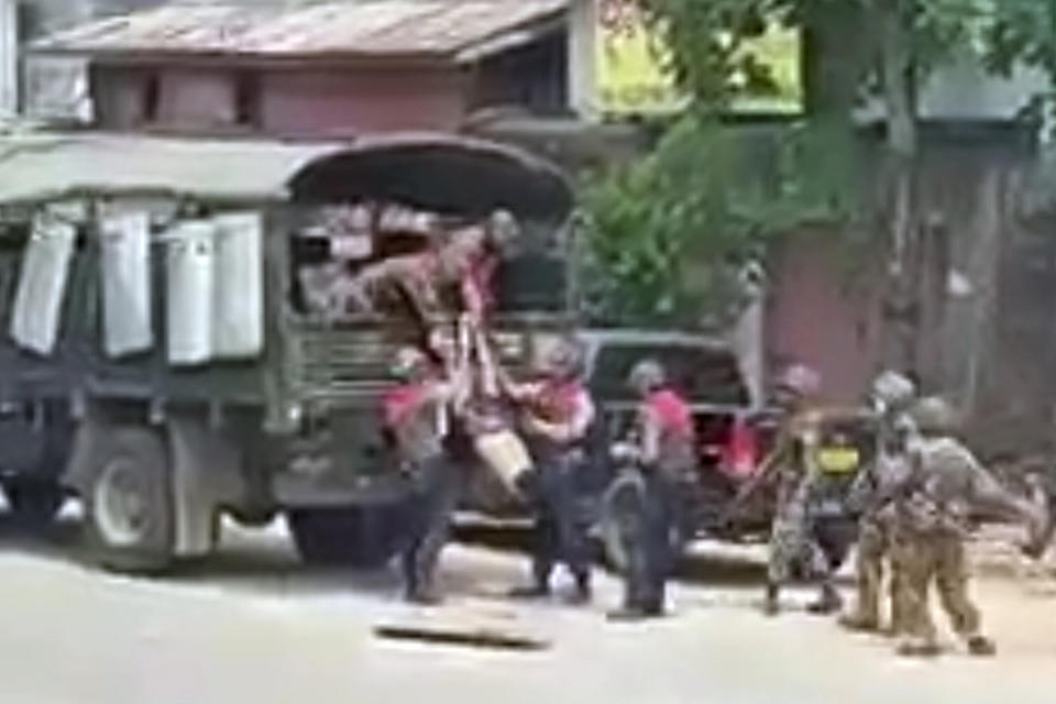 In this March 26, 2021 image from video obtained by The Associated Press, security forces pull the body of an unidentified individual into a military truck in Myeik, Myanmar. Since the military seized control of Myanmar in a takeover on Feb. 1, more than an estimated 800 people have been killed _ three times the official tally _ according to the local watchdog group Assistance Association for Political Prisoners. (AP Photo)