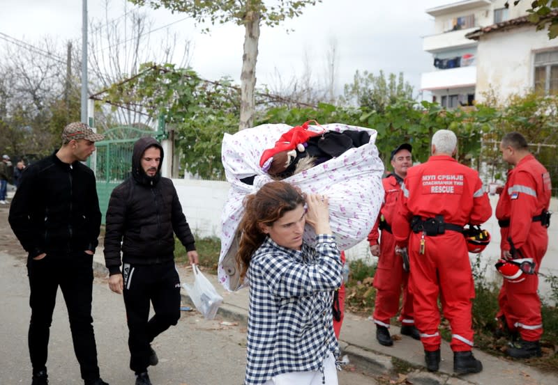Una mujer carga sus pertenencias sobre sus hombros después del poderoso terremoto del martes en Thumane, Albania, el 27 de noviembre de 2019