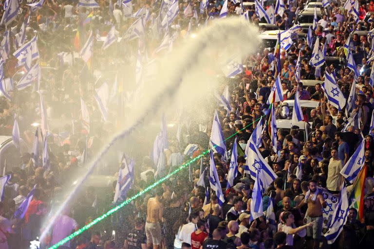 Los manifestantes son rociados con cañones de agua por la policía antidisturbios israelí durante una protesta contra el plan de reforma judicial del gobierno israelí en Tel Aviv el 24 de julio de 2023. 