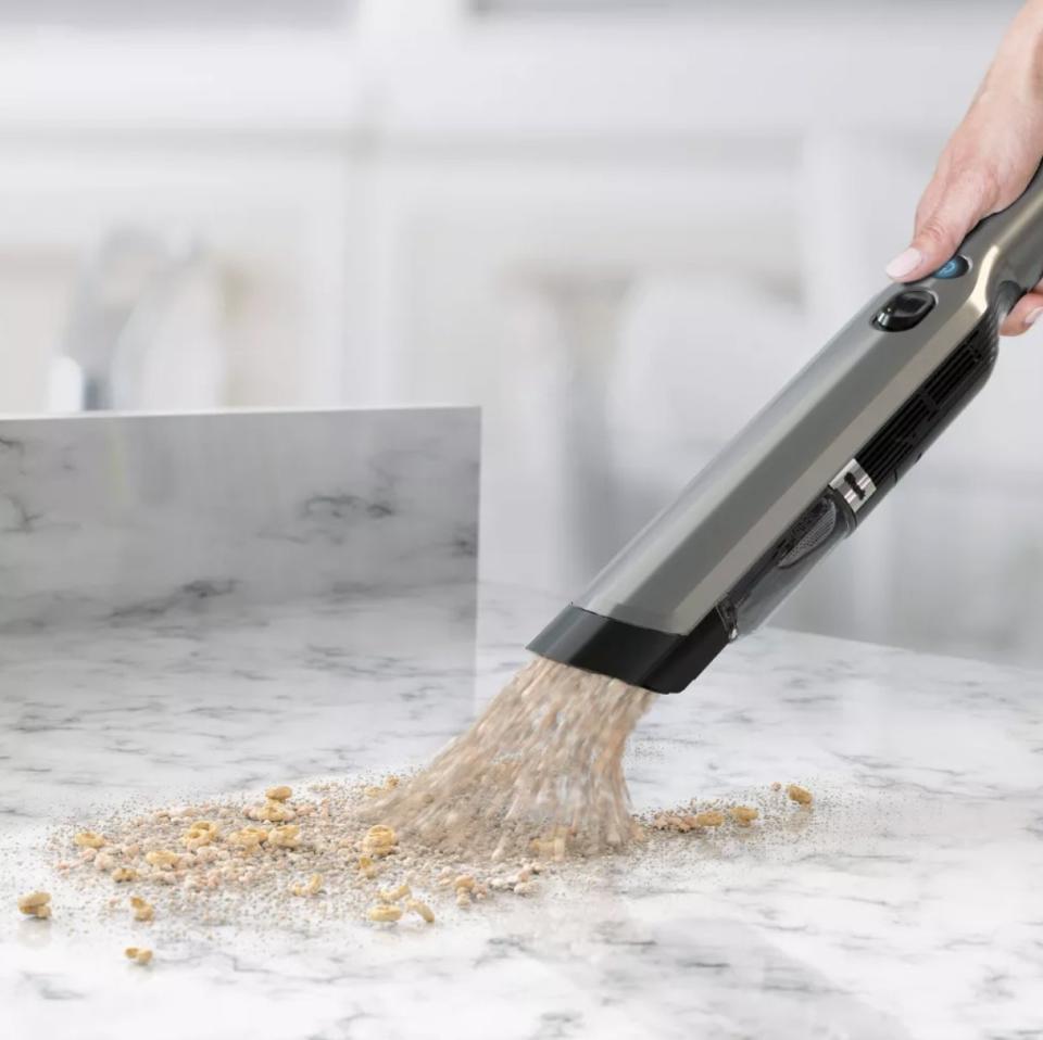 Model cleaning up spilled cereal with the same vacuum