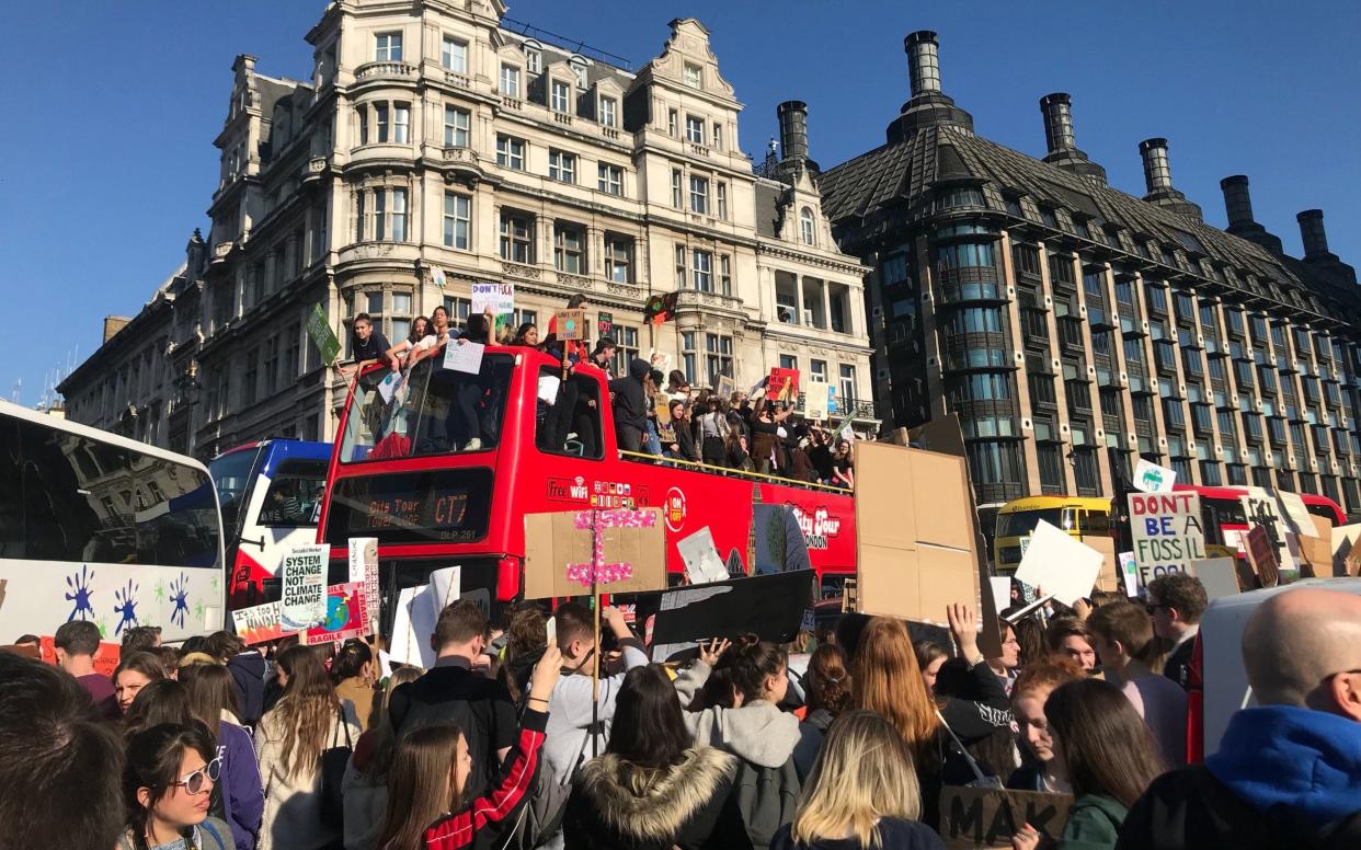 Students from the Youth Strike 4 Climate on an open top tourist bus during a climate change protest - PA