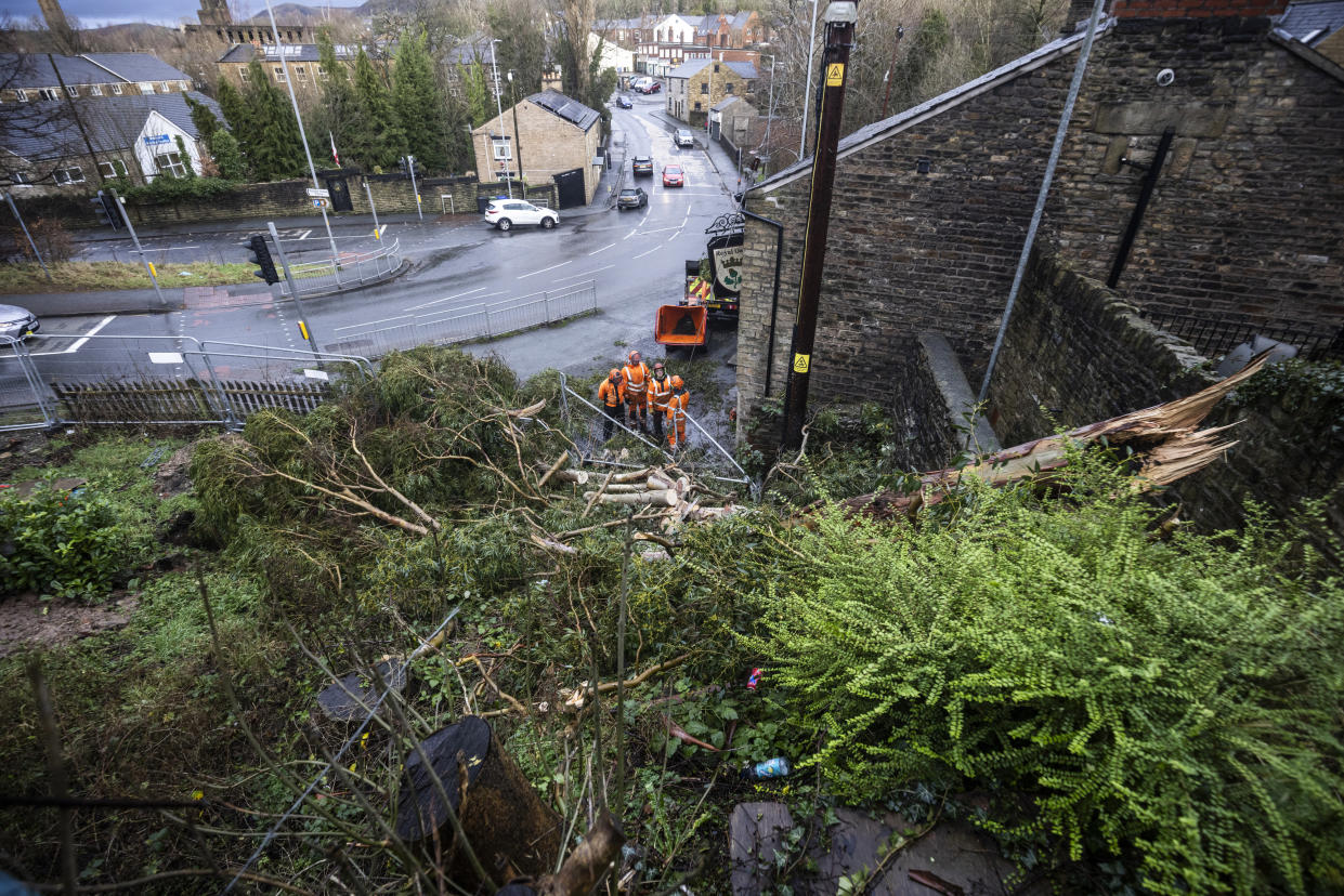 STALYBRIDGE, ENGLAND - DECEMBER 28: Electricity workers secure power lines after a tree fell onto the Royal Oak Pub in the aftermath of a tornado on December 28, 2023 in Stalybridge, England. Houses in the Tameside area of Greater Manchester have been damaged by a localised tornado during Storm Gerrit. Police declared a major incident last night as roofs were torn off the houses and trees uprooted, but no reported injuries. (Photo by Ryan Jenkins/Getty Images)