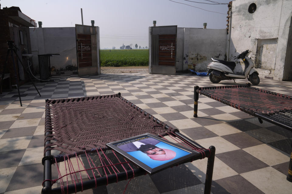 A photograph of an Indian farmer Kulwant Singh, who died during farm law protests on the borders of New Delhi lies on the charpoy, the traditional Indian cot, in his village on the outskirts of Amritsar, in Indian state of Punjab, Tuesday, Feb. 15, 2022. India's Punjab state will cast ballots on Sunday, in polls that are seen as a barometer of Prime Minister Narendra Modi's popularity ahead of general elections in 2024 and his party's Hindu nationalist reach. (AP Photo/Manish Swarup)