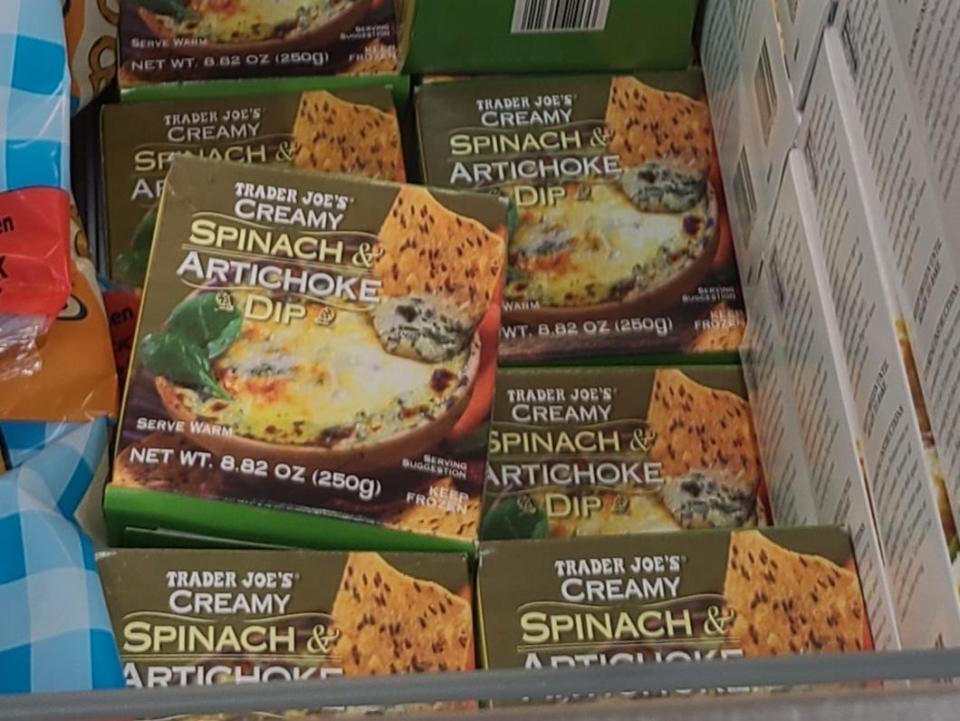 boxes of spinach and artichoke dip in the freezer aisle at trader joes