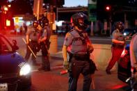 Police officers face protesters after a white police officer was caught on a bystander's video pressing his knee into the neck of African-American man George Floyd, who later died at a hospital, in St. Paul