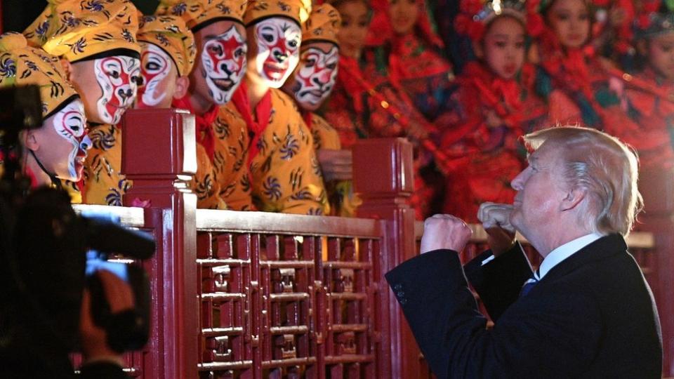 US President Donald Trump talks to opera performers beside China's President Xi Jinping (R) at the Forbidden City in Beijing on November 8, 2017.