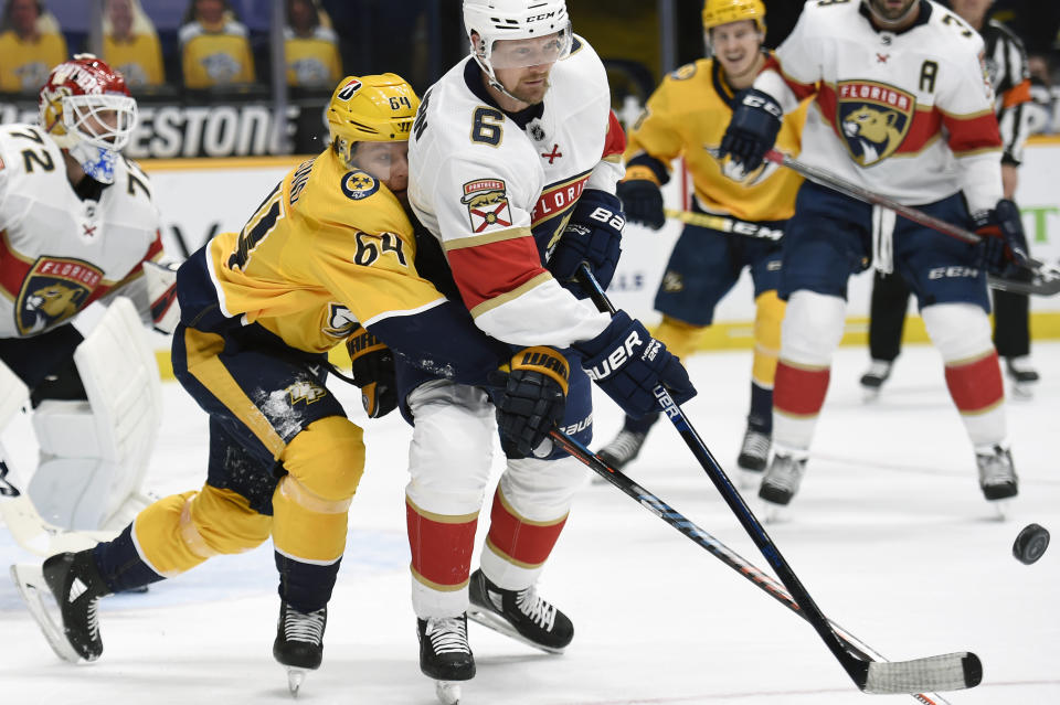 Nashville Predators center Mikael Granlund (64) and Florida Panthers defenseman Anton Stralman (6) reach for the puck during the second period of an NHL hockey game Thursday, March 4, 2021, in Nashville, Tenn. (AP Photo/Mark Zaleski)