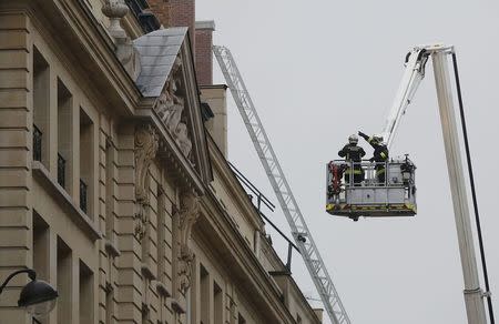 French firefighters work to tackle a fire on the roof of the luxury Ritz Paris hotel at the Place Vendome, central Paris, January 19, 2016. REUTERS/Jacky Naegelen