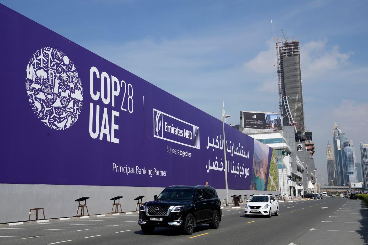 Cars pass by a billboard advertising COP28 at Sheikh Zayed highway in Dubai, United Arab Emirates, Monday, Nov. 27, 2023. Representatives will gather at Expo City in Dubai, UAE, Nov. 30 to Dec. 12 for the 28th U.N. Climate Change Conference, known as COP28. (AP Photo/Kamran Jebreili)